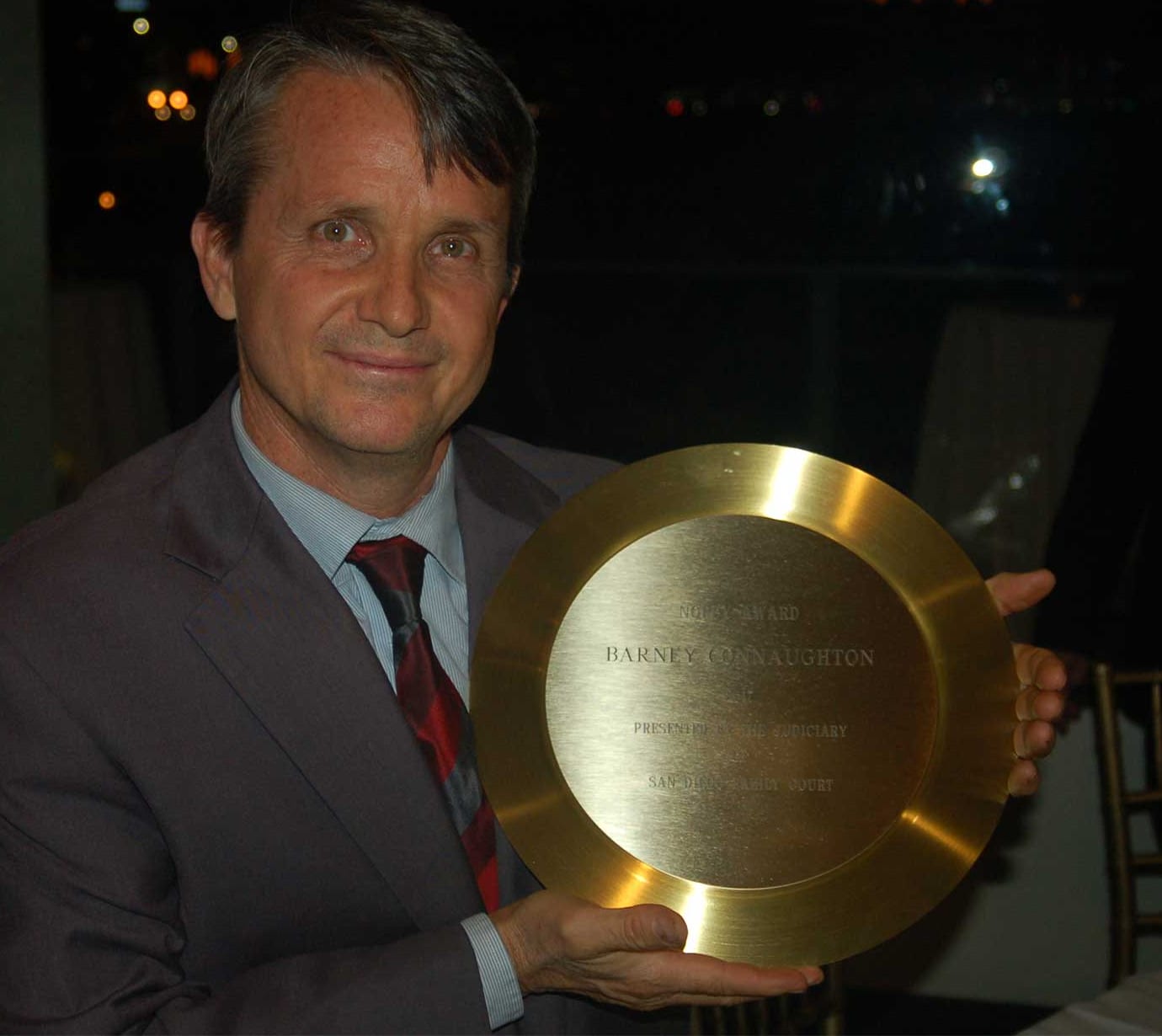 Barney Connaughton holding the Norby Award, a large gold plate engraved NORBY AWARD, BARNEY CONNAUGHTON, PRESENTED BY THE JUDICIARY, SAN DIEGO FAMILY COURT.